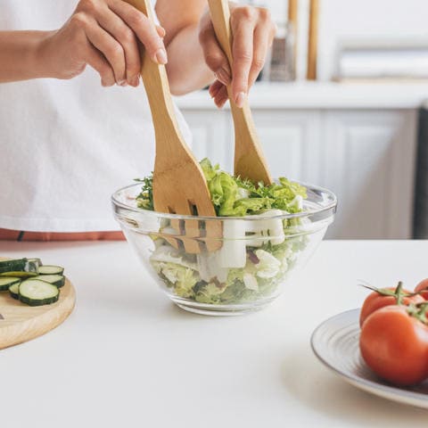 Isečena slika žene koja priprema ukusnu zdravu salatu